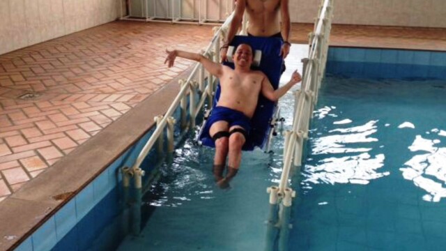APAE SRPQ cadeirante descendo a rampa assistido por profissional APAE SRPQ cadeirante descendo a rampa assistido por profissional