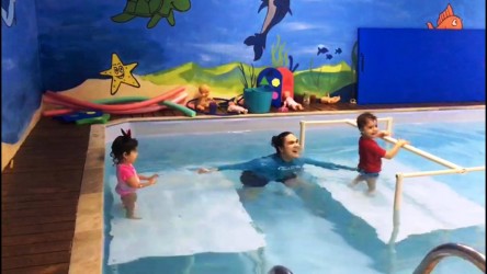 aula de natação infantil em plataforma com barra central aula de natação infantil em plataforma com barra central